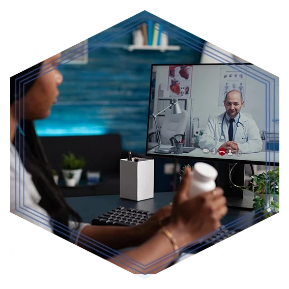 Woman holding a prescription bottle talking to a doctor through a computer