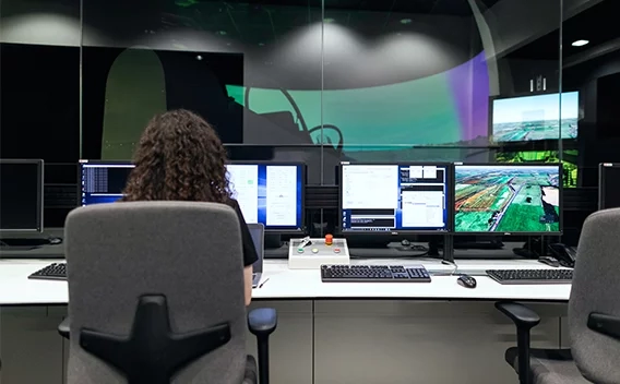 Woman sitting in an office chair looking at monitors