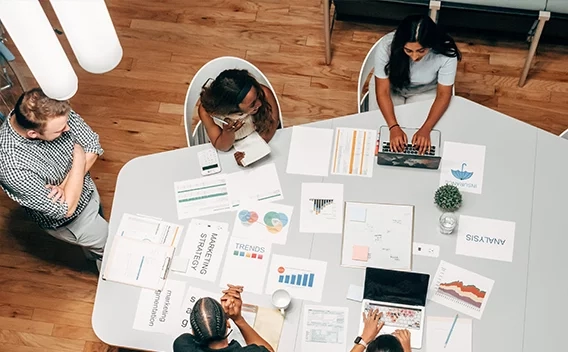 Women sitting around a conference table covered with papers