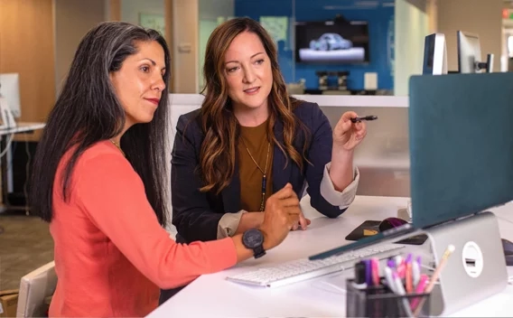 Two women looking at a monitor in an office